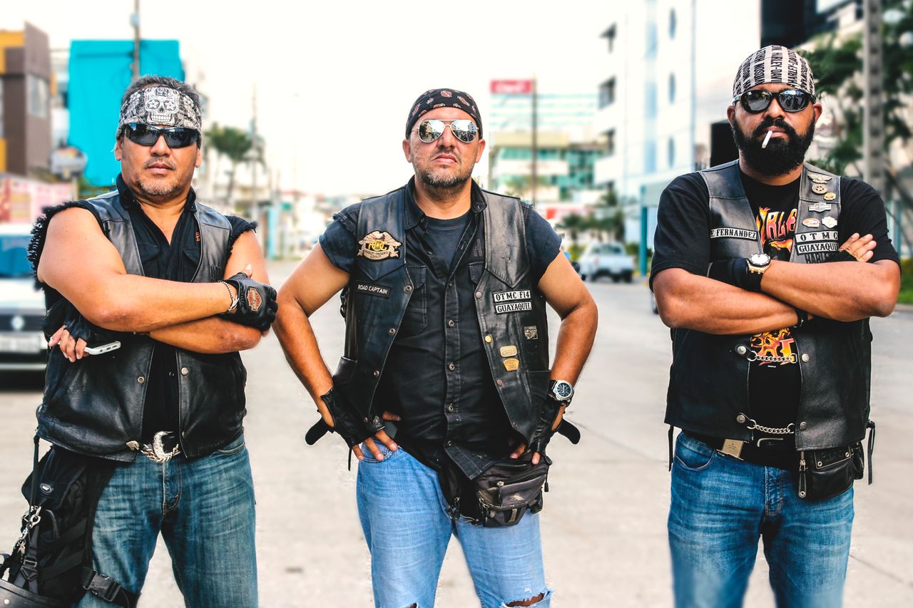 The Art of Drawing Readers In: Your attractive post title goes here Three bikers in vests and sunglasses posing confidently on a street in Guayaquil, Ecuador.